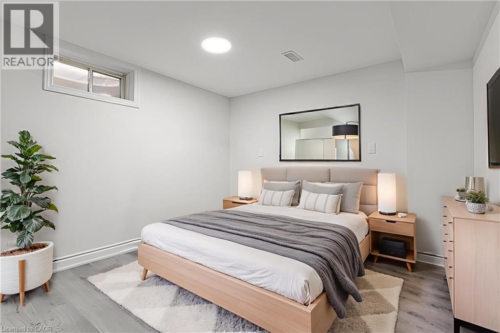 A bedroom with a bed, nightstands, and a plant.