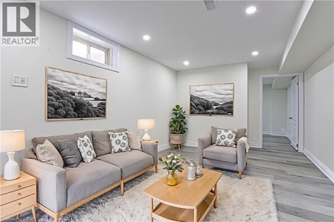 A living room with a grey couch, a wooden coffee table, and a painting on the wall.