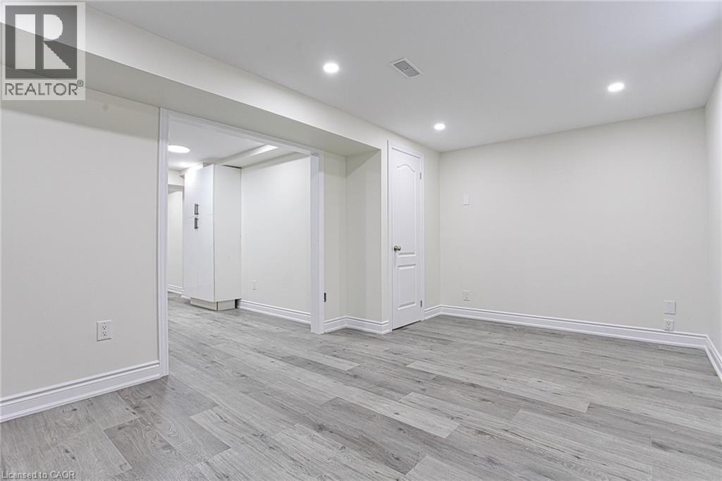 A spacious room with wood flooring and white walls.