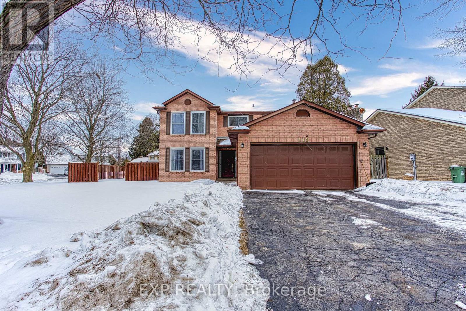 A house with a brown brick exterior and a brown garage door is surrounded by snow.