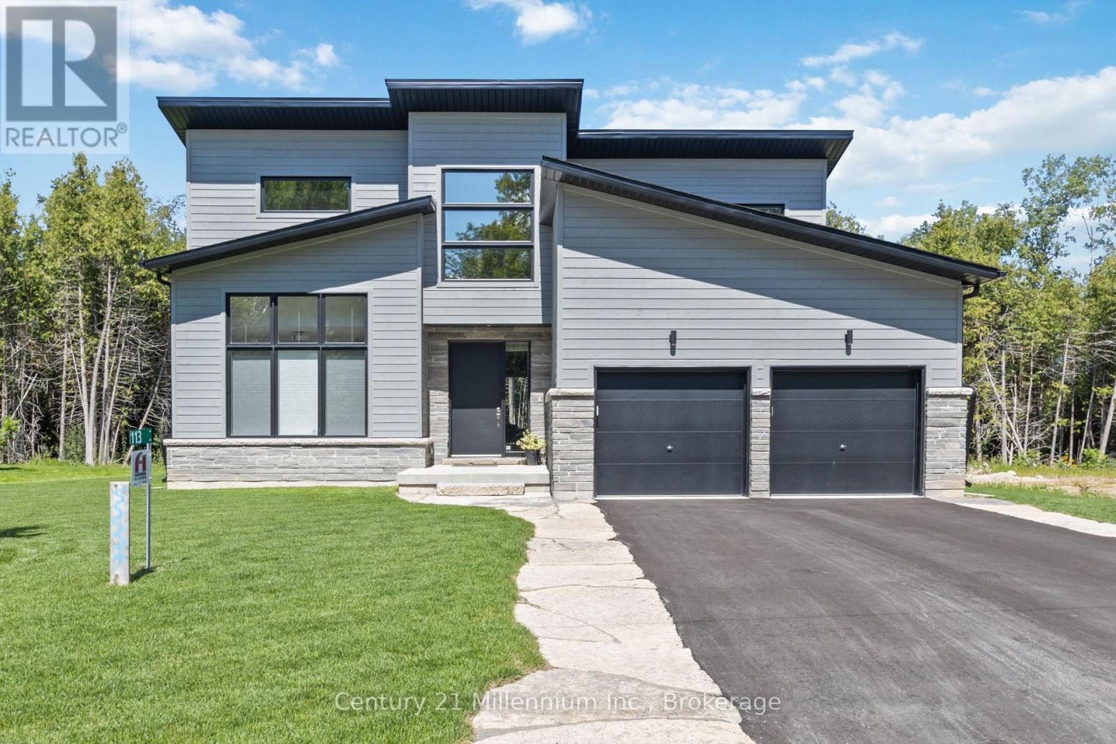 A modern house with a grey exterior and a black garage door.