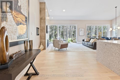A living room with a wooden floor and a large painting on the wall.