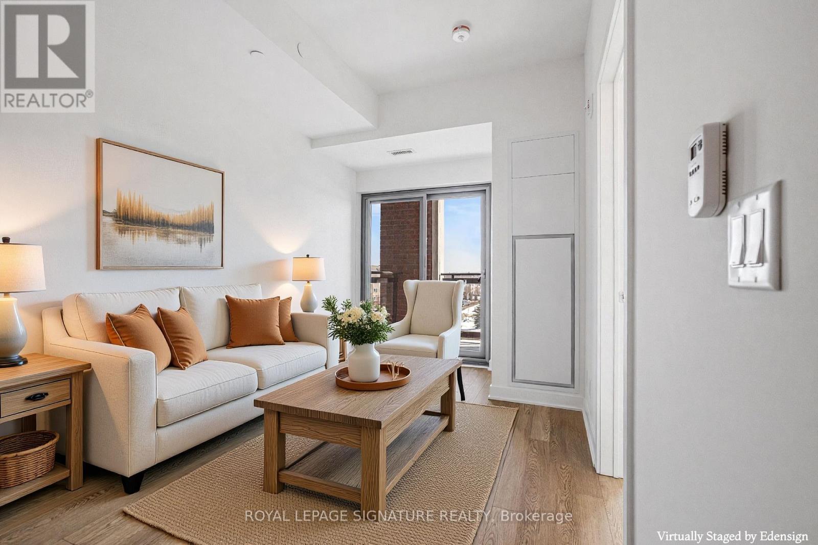 A well-lit living room with a couch, coffee table, and a painting on the wall.