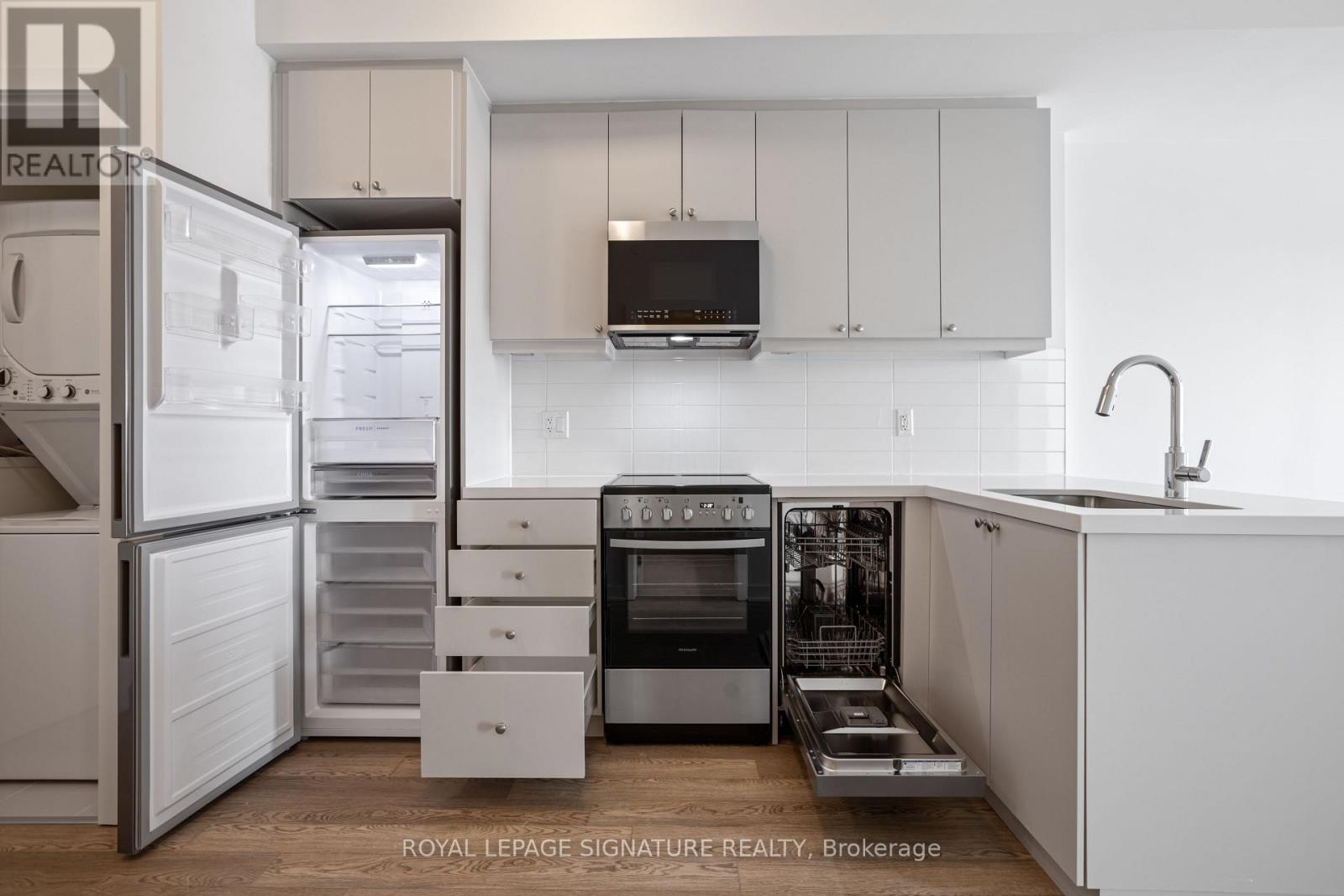 A kitchen with white cabinets and appliances.