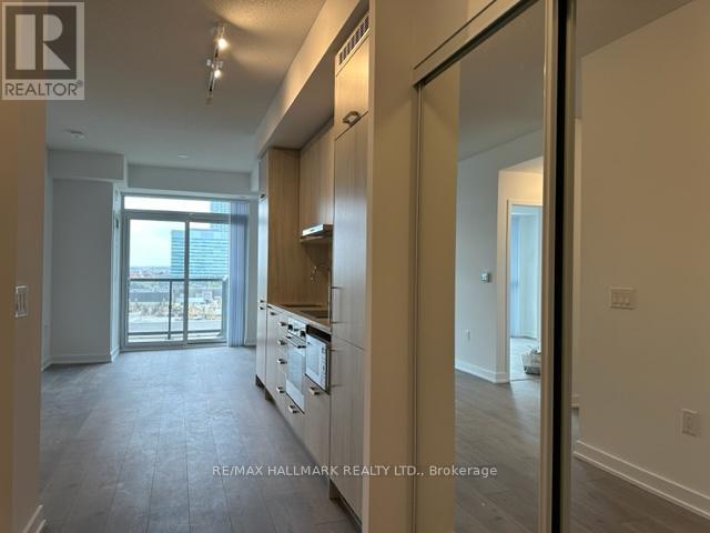 A spacious kitchen with white cabinets and a view of the balcony.