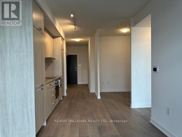 A spacious hallway with wooden floors and white walls.