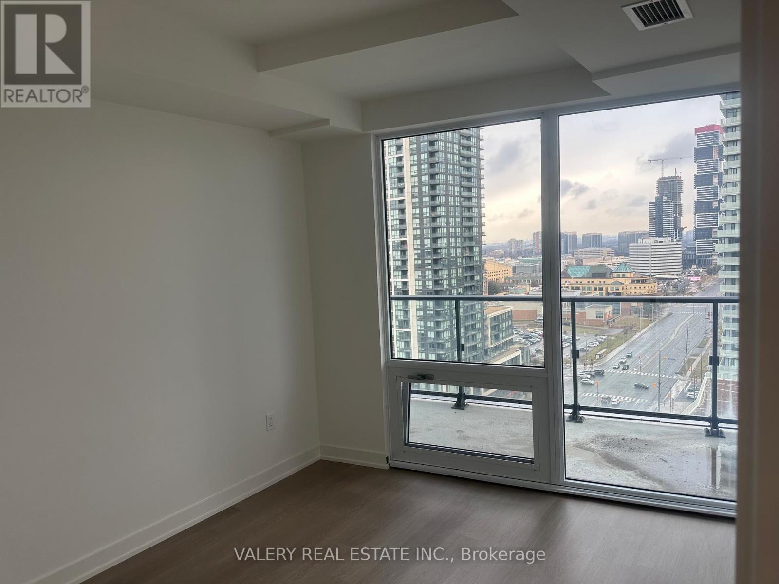 A room with a view of the cityscape through a large window.