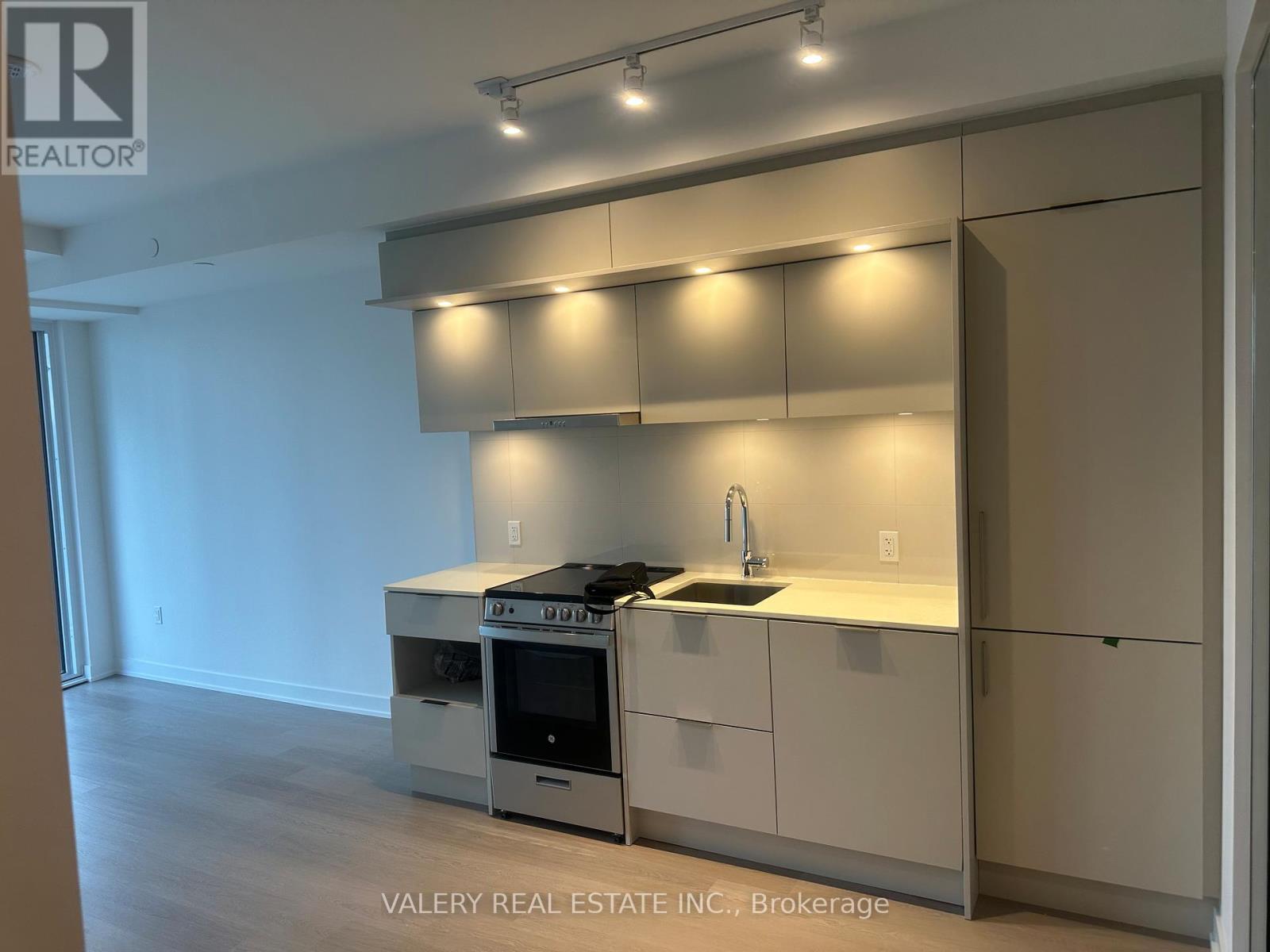 A modern kitchen with white cabinets and a stainless steel oven.