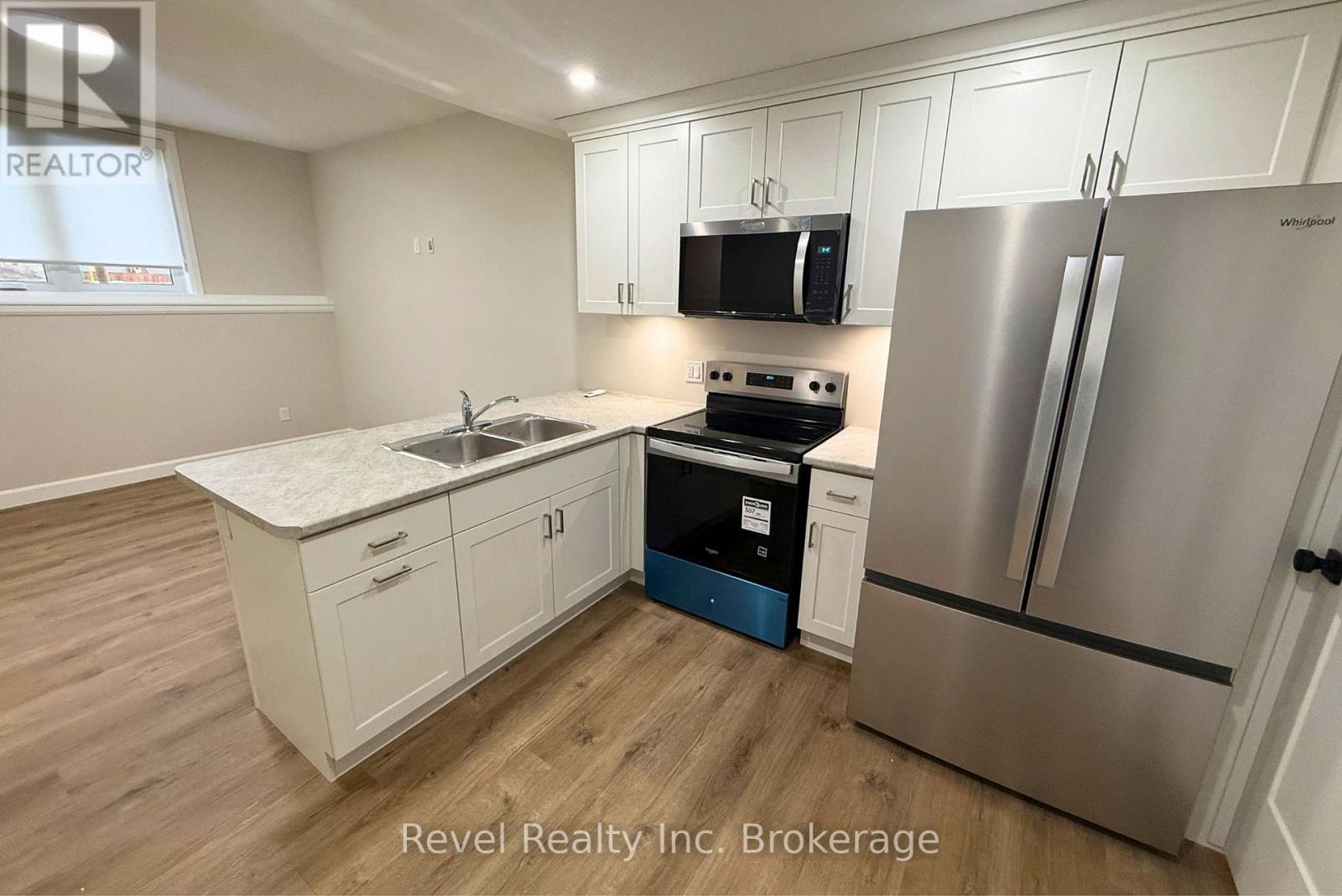 A kitchen with a stove, refrigerator, and cabinets.