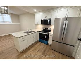 A kitchen with a stove, refrigerator, and cabinets.
