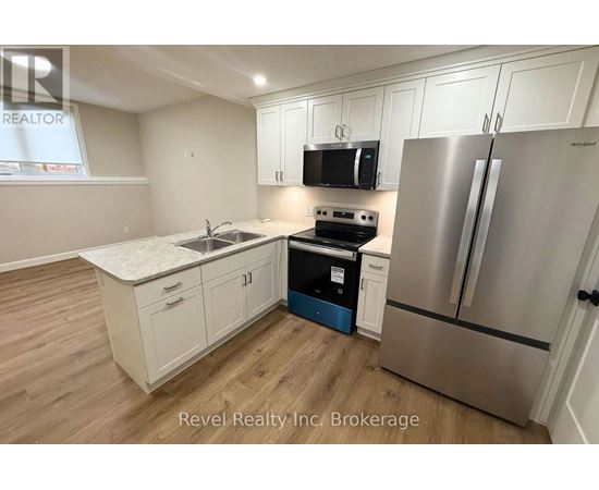 A kitchen with a stove, refrigerator, and cabinets.