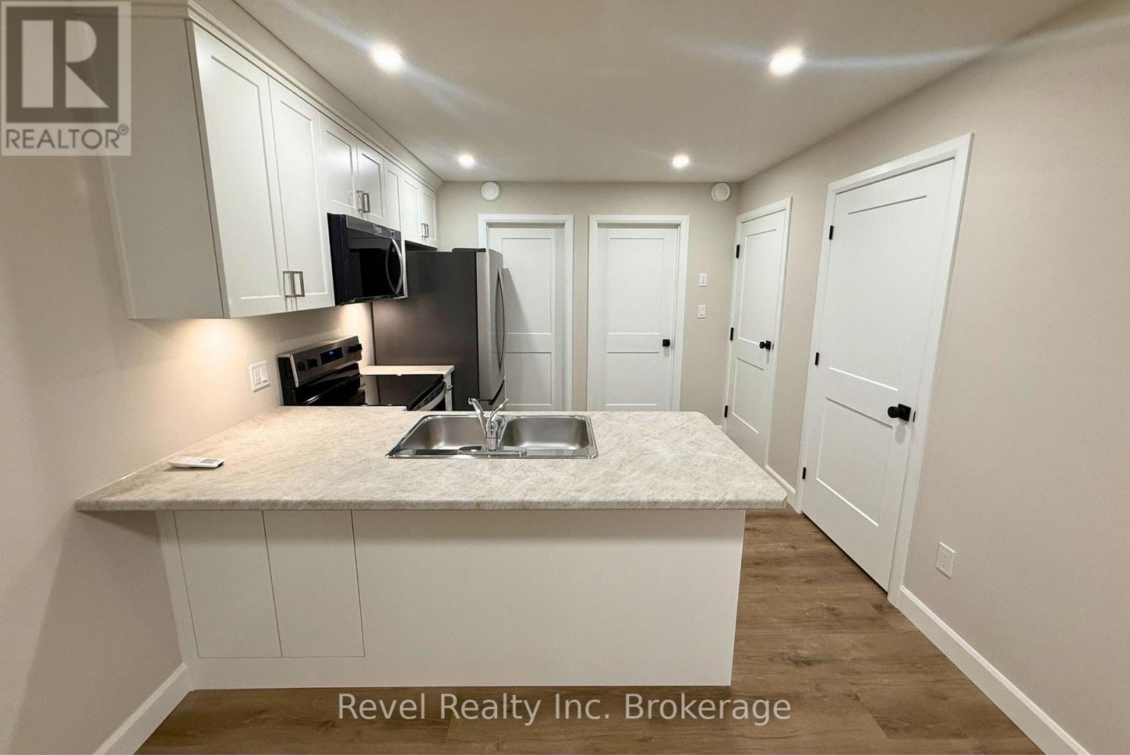 A kitchen area with a sink, microwave, and oven.