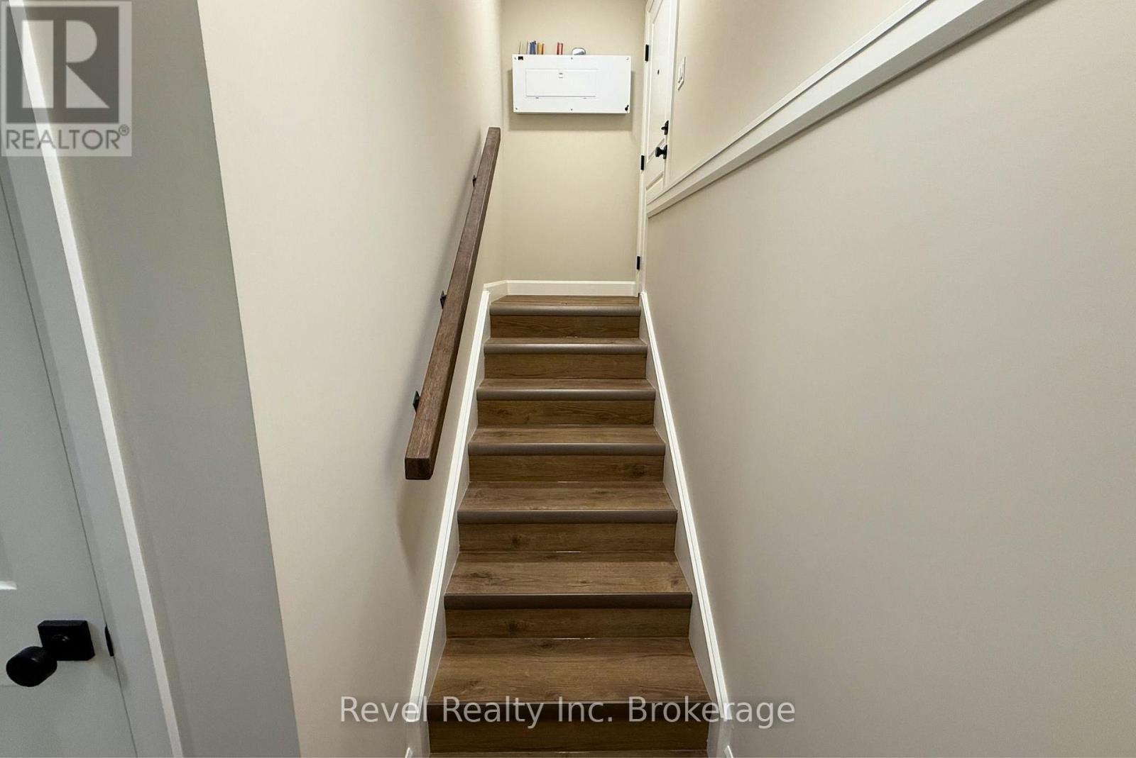 A staircase with wooden steps and a white wall.