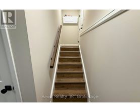 A staircase with wooden steps and a white wall.