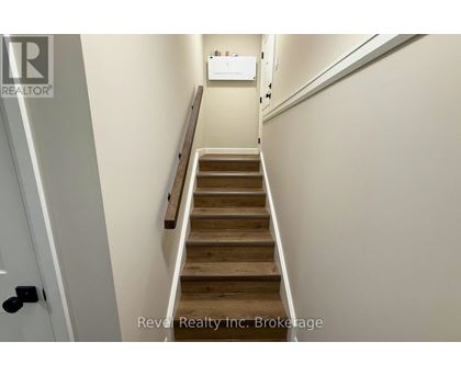 A staircase with wooden steps and a white wall.