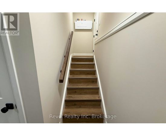 A staircase with wooden steps and a white wall.