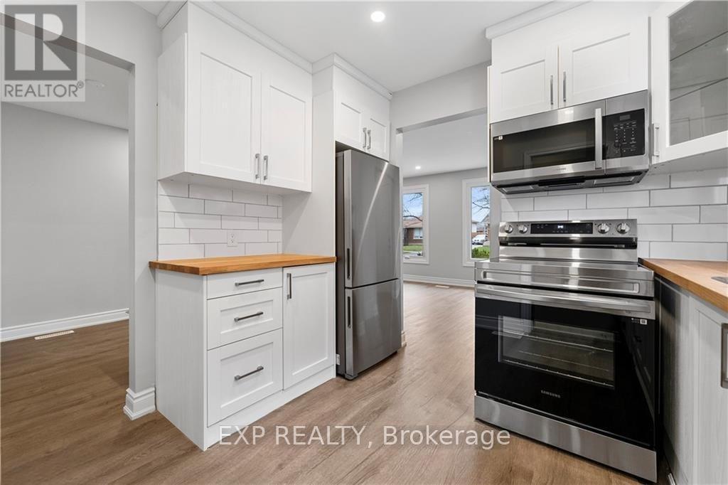 A kitchen with white cabinets and stainless steel appliances.