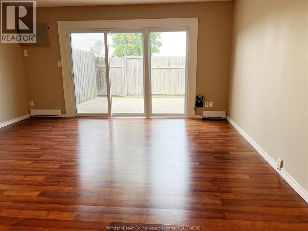 A room with wooden floors and a sliding glass door.