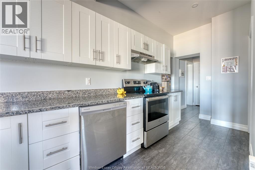 A kitchen with white cabinets and a granite countertop.
