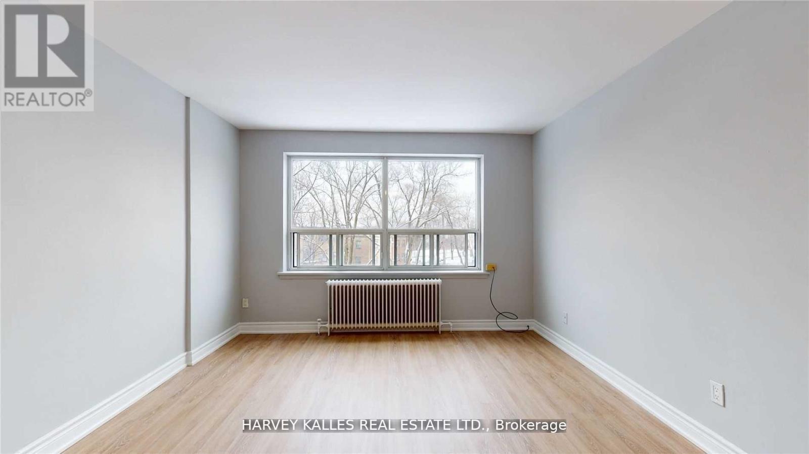 A room with a window and a radiator on the floor.
