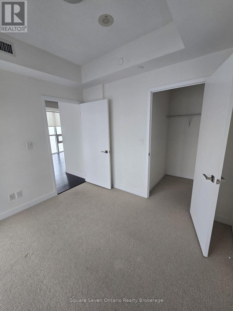 A realtor photo of a bedroom with a carpeted floor and two doors.