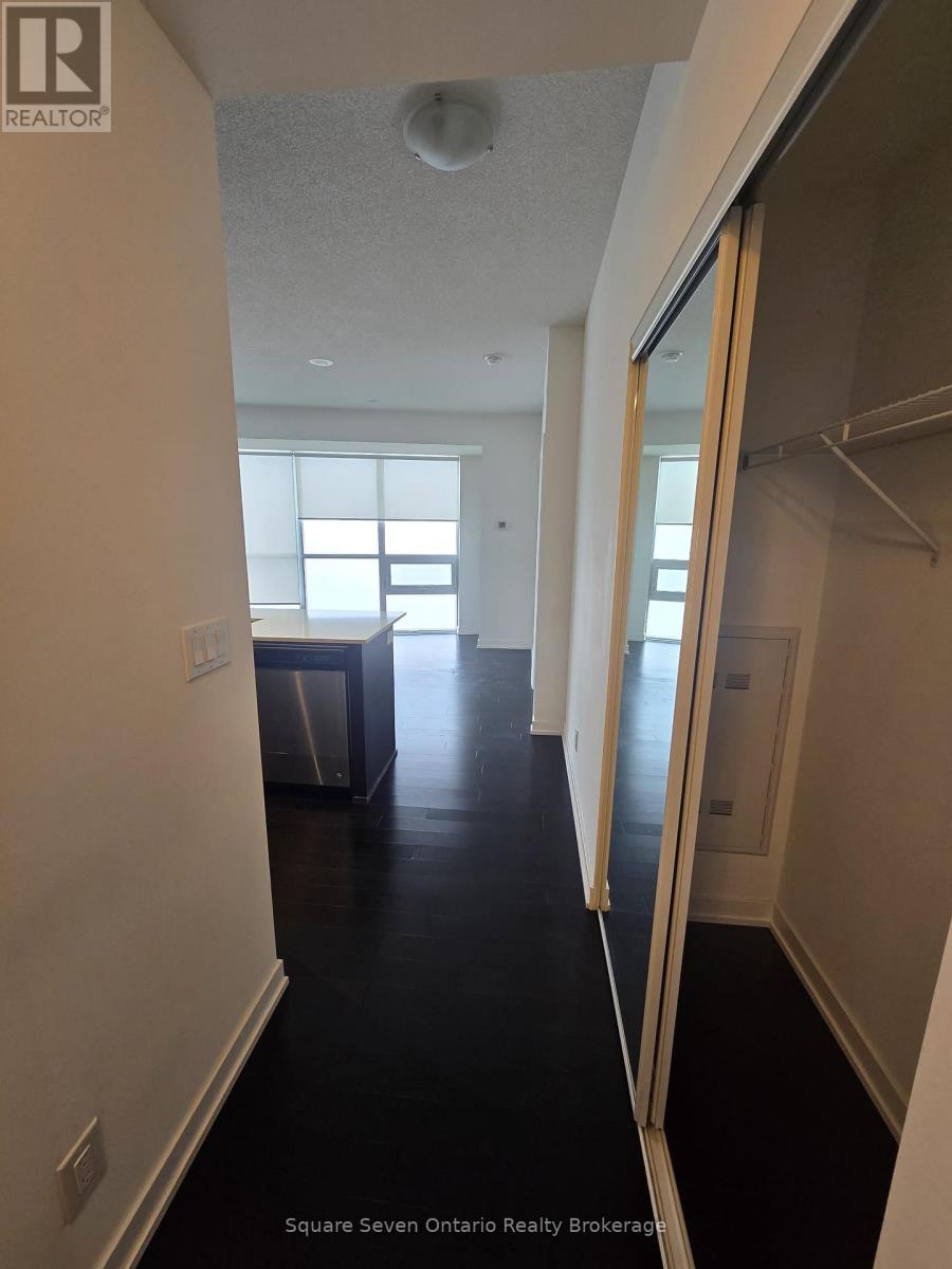 A long hallway with a door on the right and a window on the left.