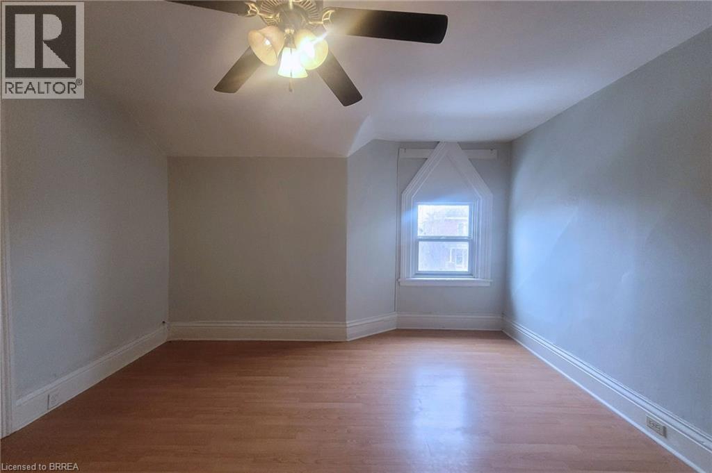 A room with a ceiling fan and a window.