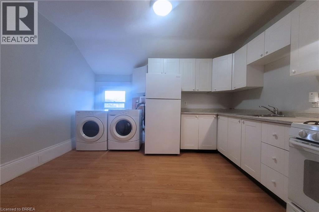 A kitchen with white cabinets and a wooden floor.