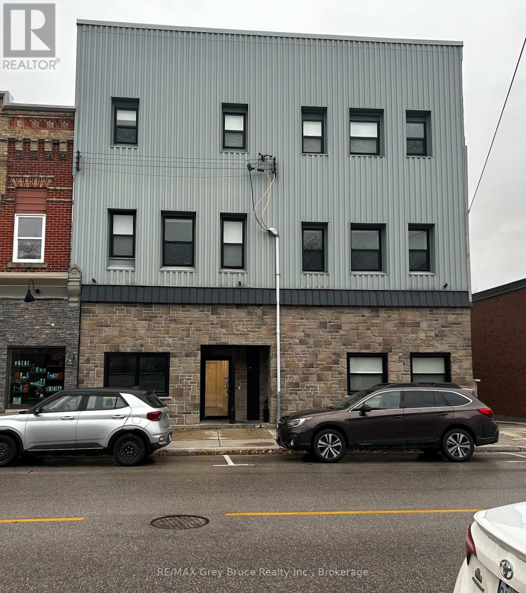 A grey building with a REALTOR sign on it.