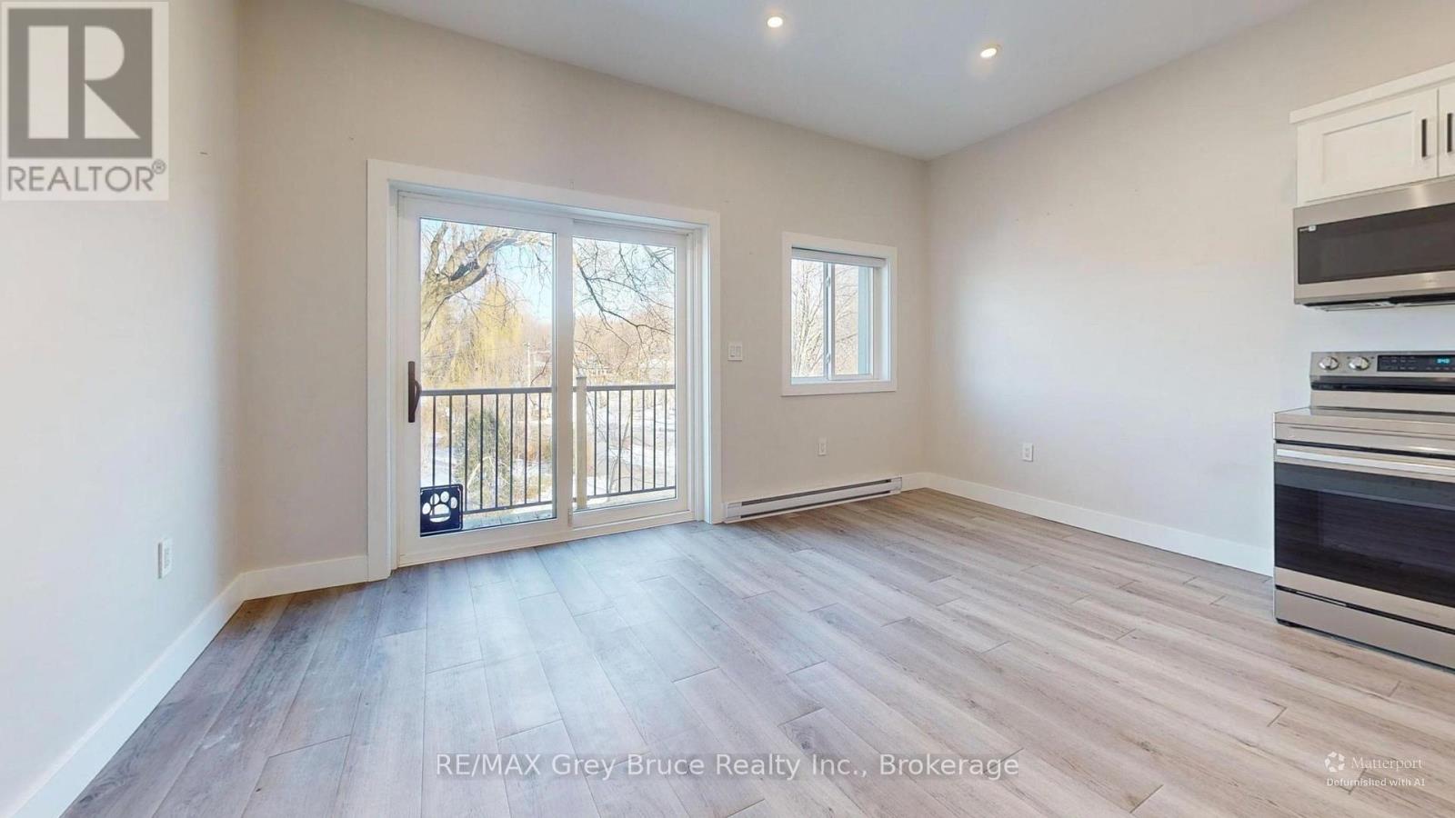 A spacious room with a sliding glass door leading to a balcony.