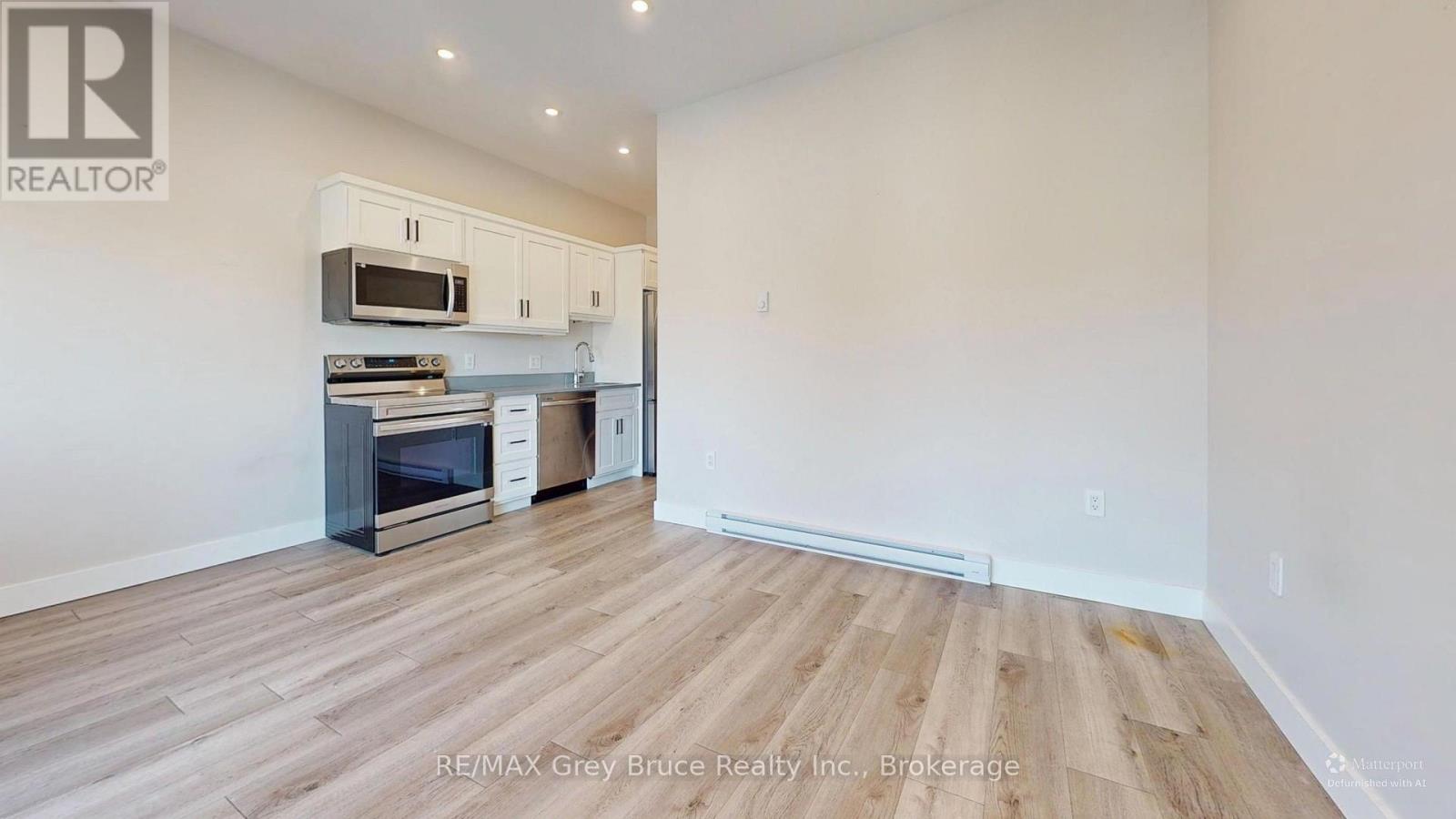 A kitchen with a microwave and oven built into the cabinetry.