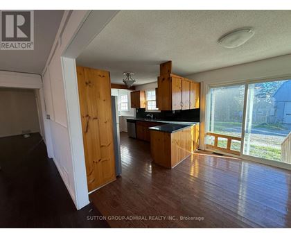 A kitchen with wooden cabinets and a black countertop is shown in this image.