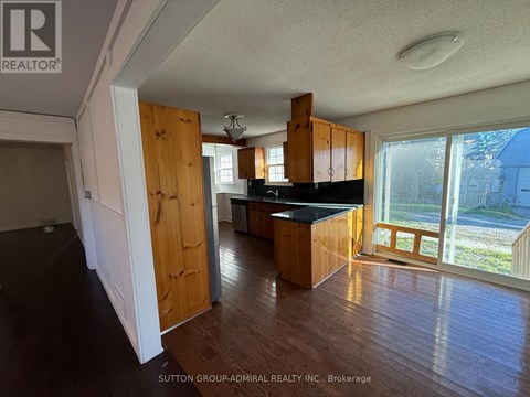 A kitchen with wooden cabinets and a black countertop is shown in this image.