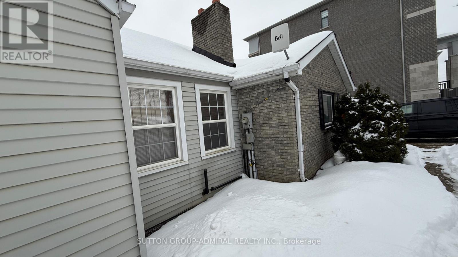A house with a snow-covered ground and a chimney.