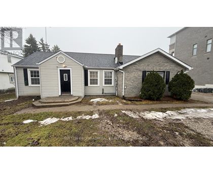 A house with a snow-covered ground and a chimney.
