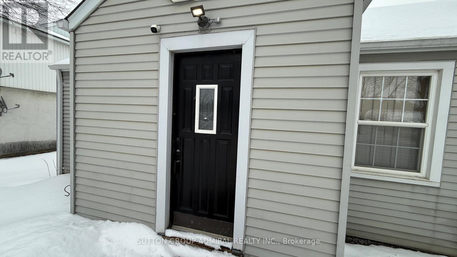 A house with a black door and a sign that says REALTOR.