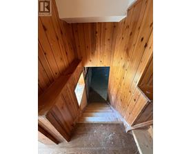A wooden staircase leading to a dark space.
