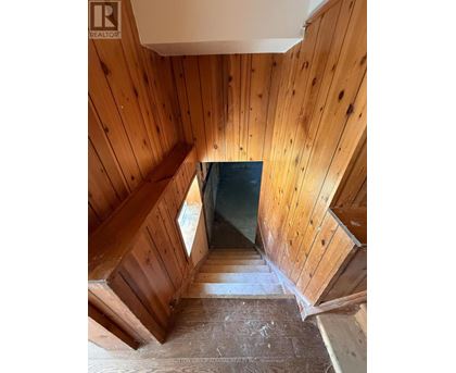 A wooden staircase leading to a dark space.