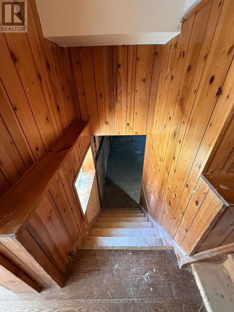 A wooden staircase leading to a dark space.