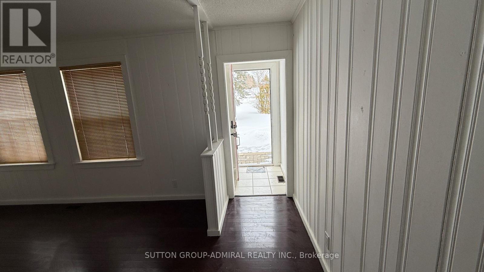A room with a doorway leading to a snowy landscape.