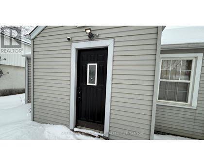 A room with a doorway leading to a snowy landscape.