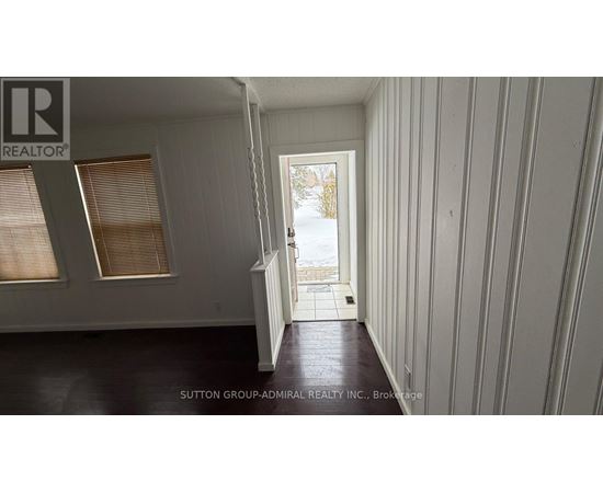 A room with a doorway leading to a snowy landscape.