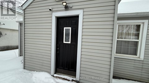 A room with a doorway leading to a snowy landscape.