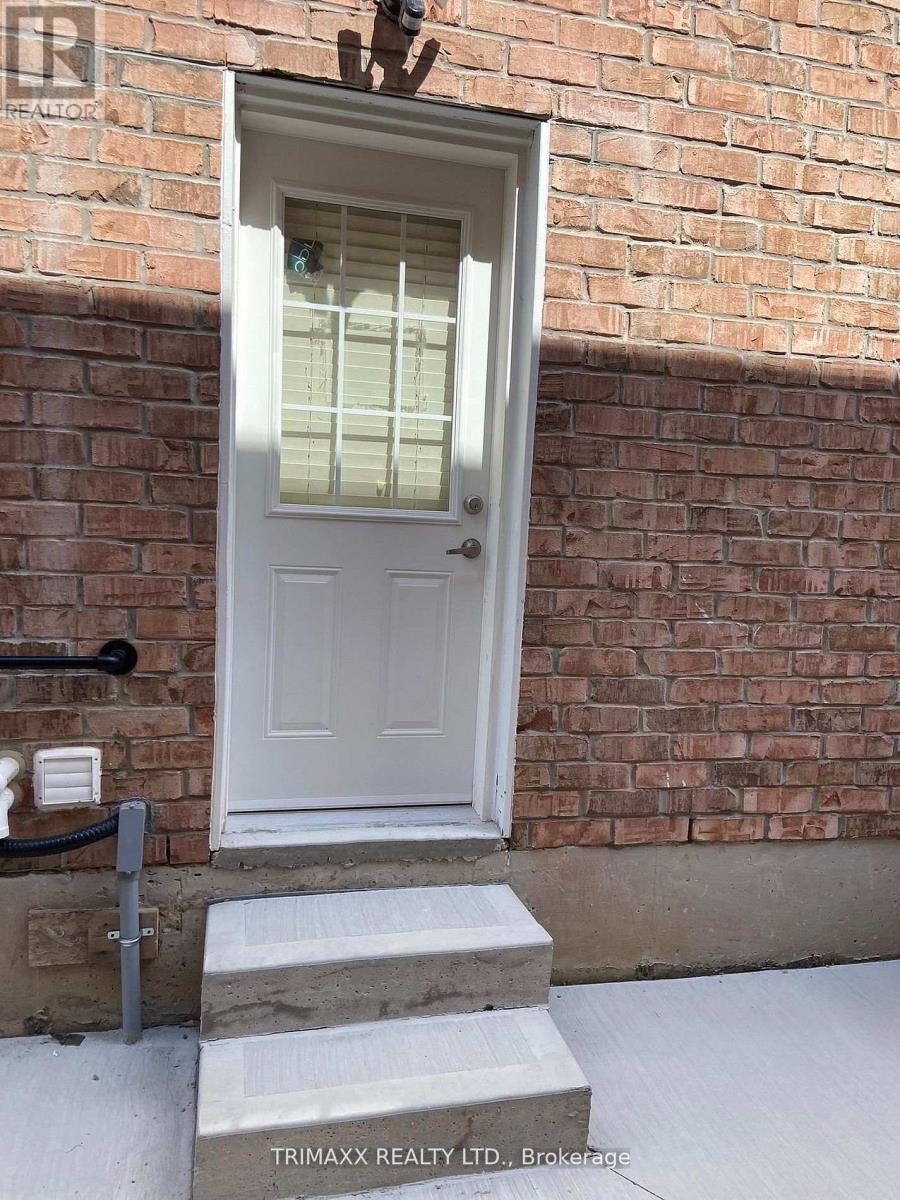 A white door with a glass window is set in a brick wall.