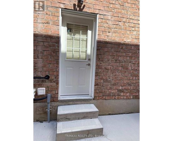 A white door with a glass window is set in a brick wall.