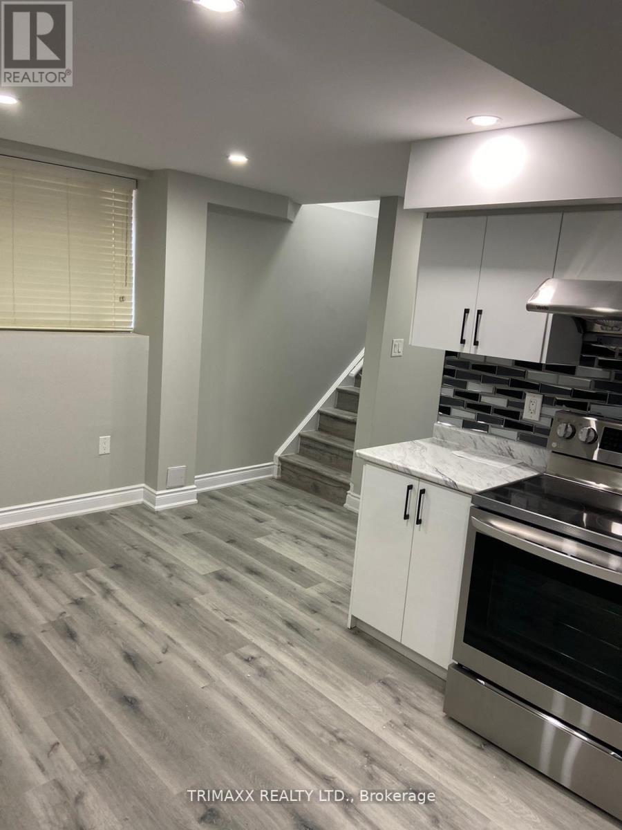 A kitchen with a stainless steel oven and white cabinets.