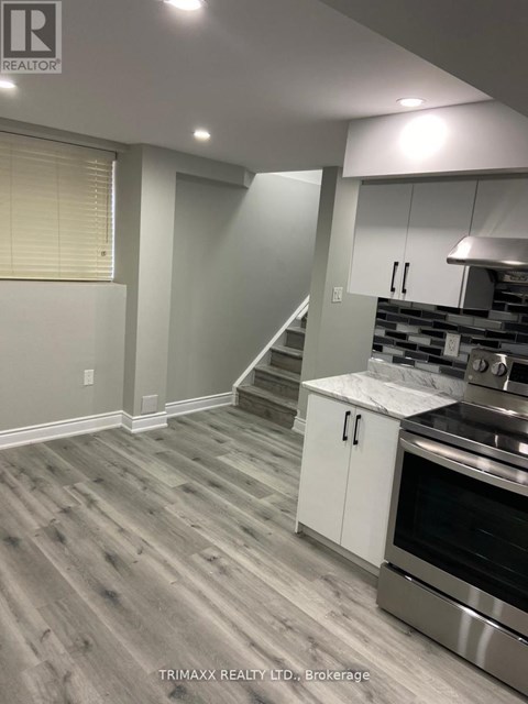 A kitchen with a stainless steel oven and white cabinets.