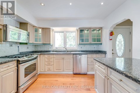 A kitchen with wooden cabinets and granite countertops.