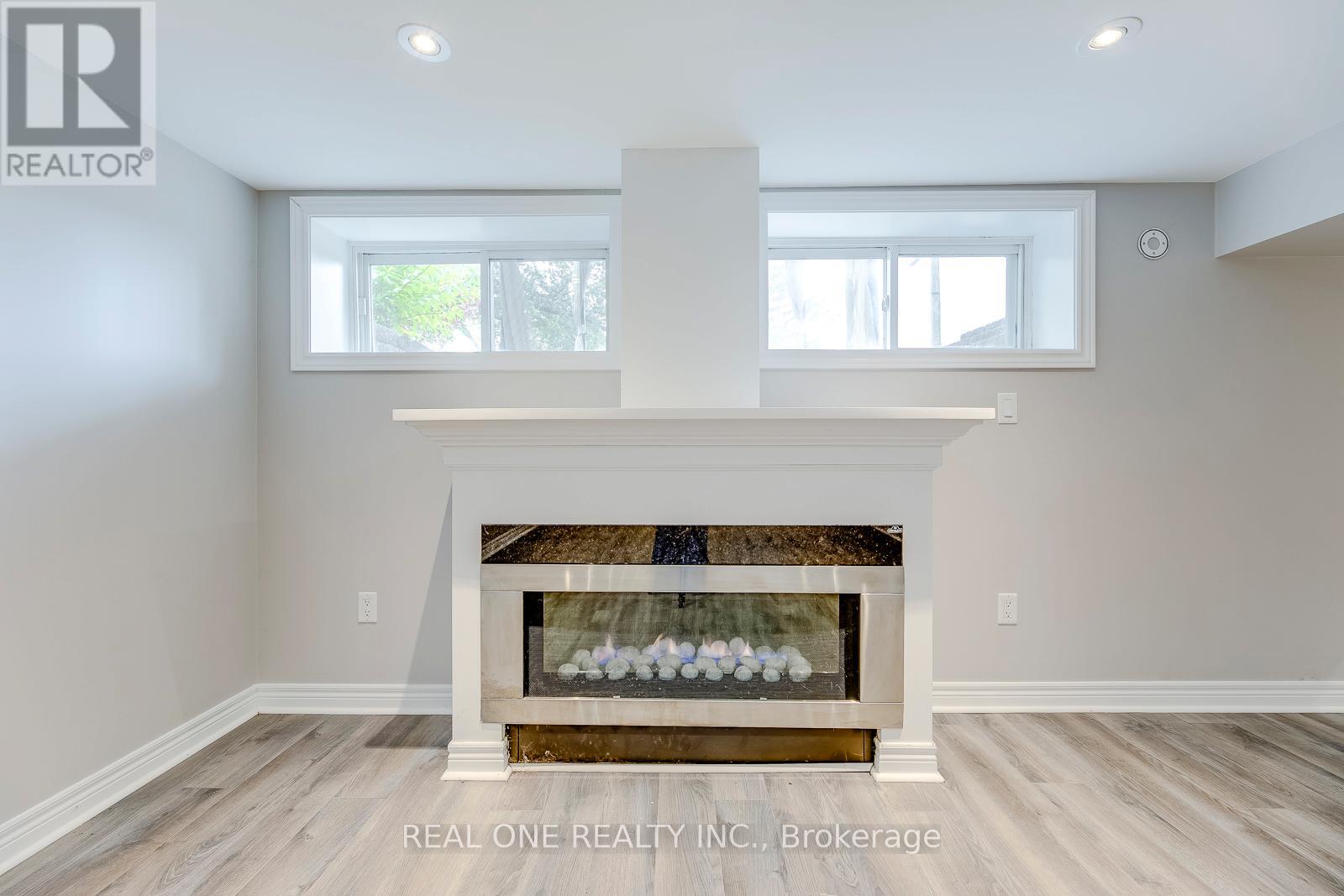 A modern living room with a fireplace and a large window.