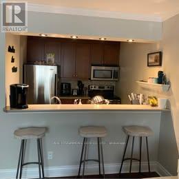 A kitchen with a white counter and bar stools.